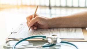 Close-up of a doctor writing down information on a patient's form