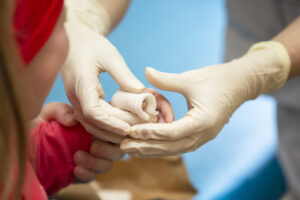 The hands of the doctor bandage the sore finger with a bandage of the child. Injury and wound on the finger in children