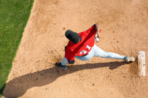 Image of young baseball pitcher on mount throwing ball