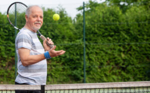Man playing tennis after recieving bone fracture treatment